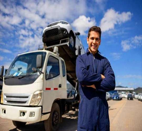 Chauffeur de camion heureux avec une cargaison de voitures